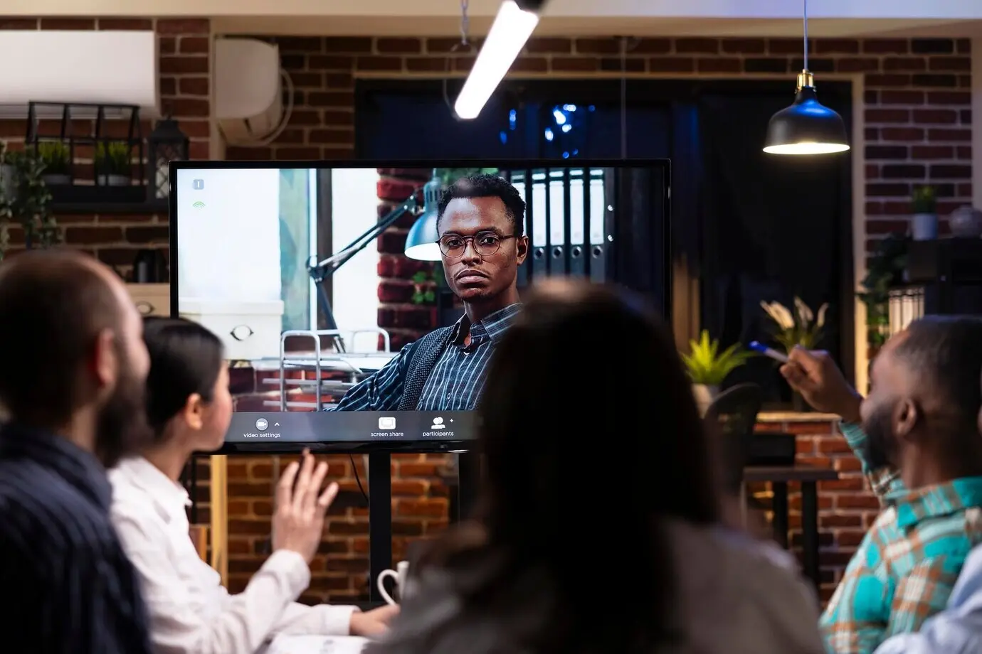 Schwarzer Mann bei einem Videoanruf mit vielfältigen Kolleginnen und Kollegen